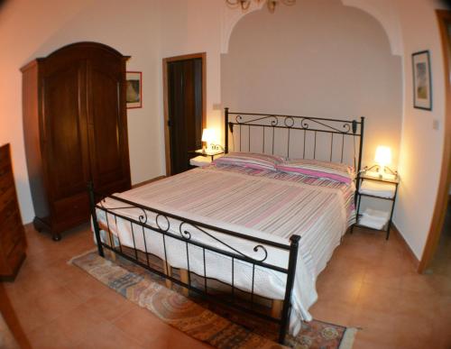 a bedroom with a large bed with two lamps at Casa Romeo in Adrano
