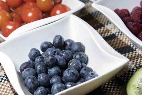 a bowl of blueberries and other fruit on a table at Landhaus Rudigier in Sankt Gallenkirch