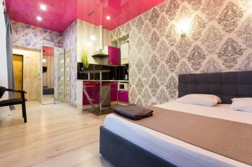 Il comprend une chambre avec un grand lit et une cuisine. dans l'établissement Studio apartment in the Center - Heroiv Nebesnoi Sotni sq. 21/7, à Kharkov