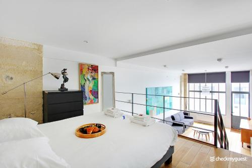um quarto branco com uma cama e uma varanda em CMG Faubourg Saint-Martin em Paris