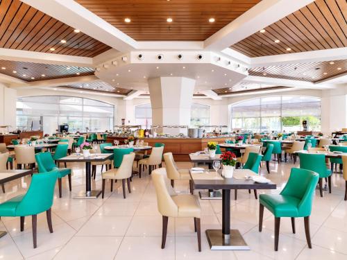 a dining room with tables and chairs at St Raphael Resort in Limassol