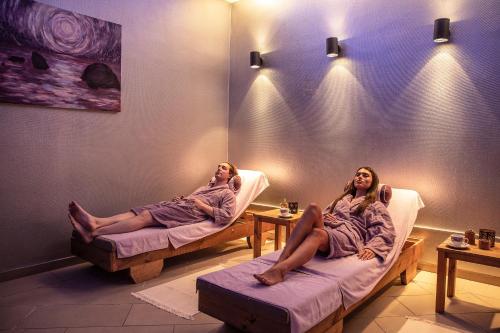 two women in towels sitting in chairs in a room at St Raphael Resort in Limassol