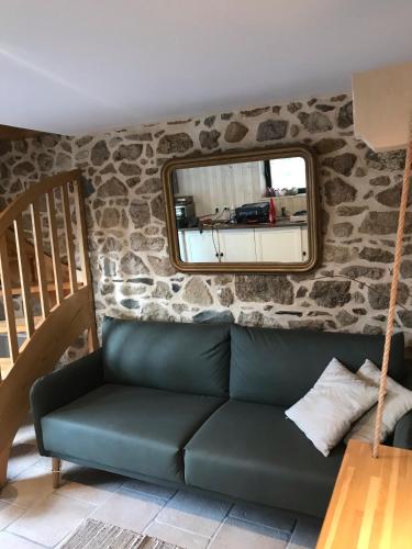 a living room with a green couch and a mirror at À L'orée Du Bois in Pommerit-le-Vicomte