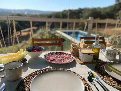a table with plates and bowls of food on it at La Siesta del Naranjo in Monesterio