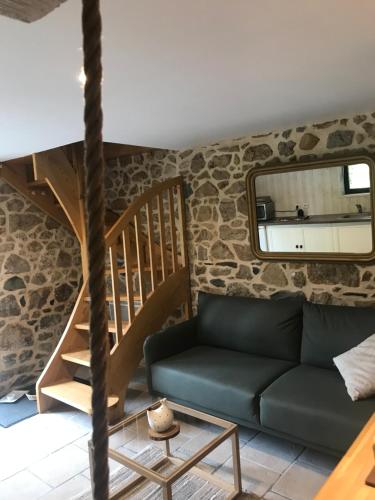 a living room with a couch and a staircase at À L'orée Du Bois in Pommerit-le-Vicomte