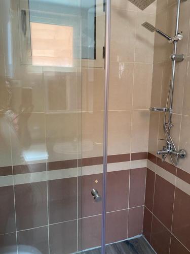 y baño con ducha y puerta de cristal. en Durres Apartment Panoramic Sea, en Durrës