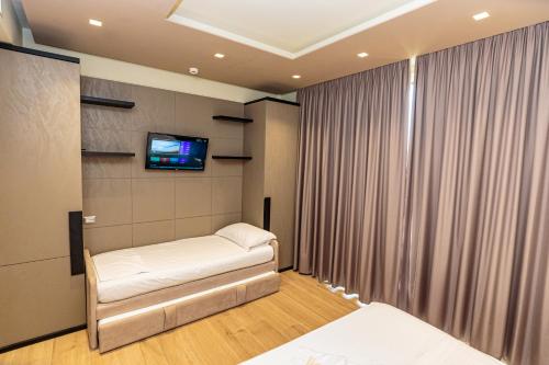 Zimmer mit 2 Betten und einem Flachbild-TV in der Unterkunft Vogue Boutique Hotel in Vlorë