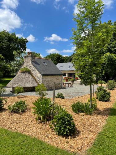 a garden in front of a stone house at À L'orée Du Bois in Pommerit-le-Vicomte