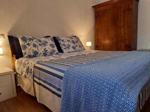 een slaapkamer met een blauw en wit bed met 2 kussens bij Casa "ALCENTRO" in Assisi