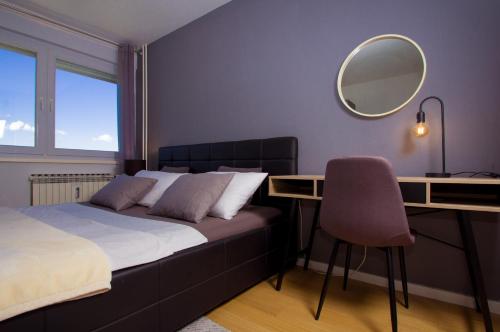 een slaapkamer met een bed, een bureau en een spiegel bij Apartment Zagreb 213 in Zagreb