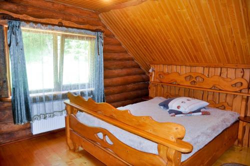 a bedroom with a bed in a log cabin at Садиба Курортна in Zhdenievo