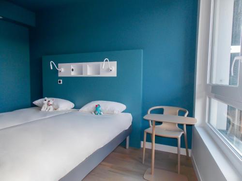 a small bedroom with two beds and a chair at ibis budget Rouen Centre Rive Gauche in Rouen