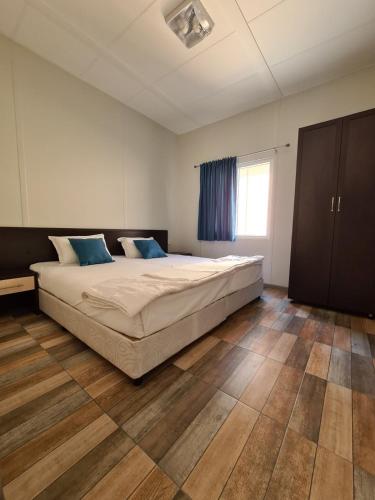 a bedroom with a large bed with blue pillows at Бунгала Калина - Нестинарка in Tsarevo