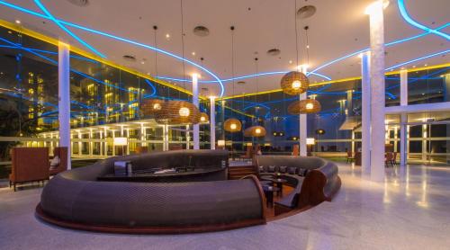 a lobby with a large couch in the middle of a building at Vivanta Colombo, Airport Garden in Negombo