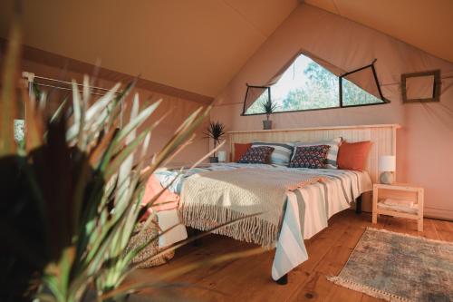 ein Schlafzimmer mit einem Bett in einem Zimmer mit einem Fenster in der Unterkunft Glamping Mandra Kanev in Leplyavo