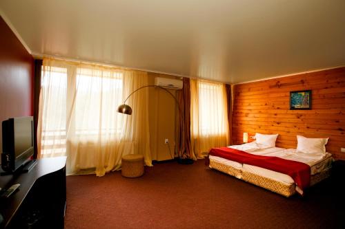 a hotel room with a bed and a television at Spa Hotel Select - Halfboard in Velingrad