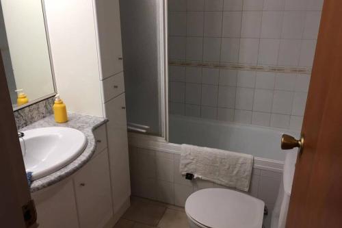 een badkamer met een witte wastafel en een toilet bij charme et simplicité de ce nouveau bien in Empuriabrava
