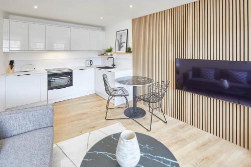 Host & Stay - Golden Lion Apartments في ويتبي: مطبخ وغرفة معيشة مع طاولة وكراسي