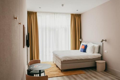 une chambre d'hôtel avec un lit et une table dans l'établissement Hotel Bries Den Haag - Scheveningen, à La Haye