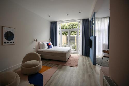 ein Wohnzimmer mit einem Sofa und einem Stuhl in der Unterkunft Hotel Bries Den Haag - Scheveningen in Den Haag