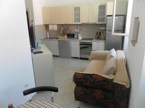 a kitchen with a couch and a kitchen with appliances at Apartments David in Perast