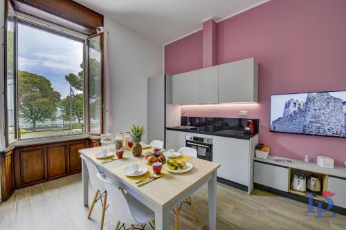 una cucina con tavolo e sedie bianchi in una stanza di DesenzanoLoft Palazzo Visconti Luxury Suite a Desenzano del Garda