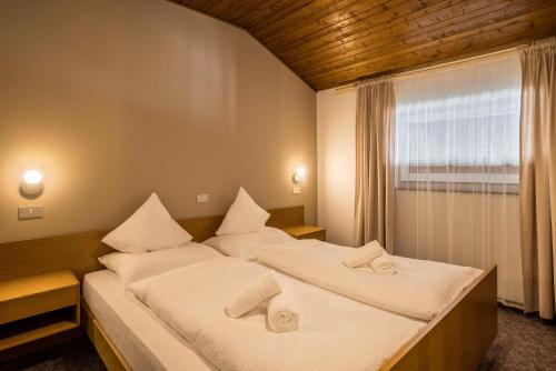 - une chambre avec 2 lits et une fenêtre dans l'établissement Apt Hofer Silena, à Villabassa