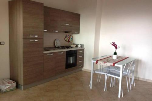羅薩島的住宿－Grazioso appartamento Isola Rossa，厨房配有桌子和桌椅