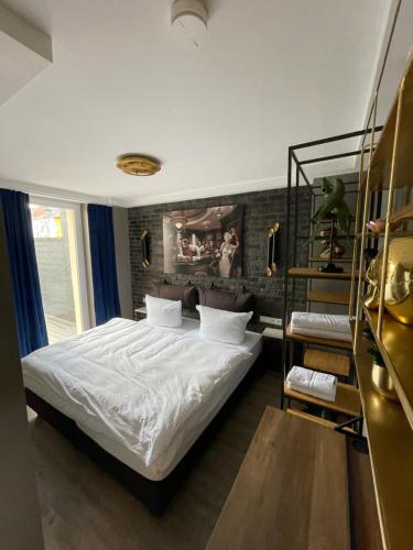 IQ Hotel Hannover في هانوفر: غرفة نوم بسرير وجدار من الطوب