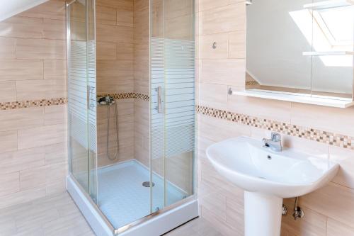 a bathroom with a glass shower and a sink at Seafront apartments in Tivat