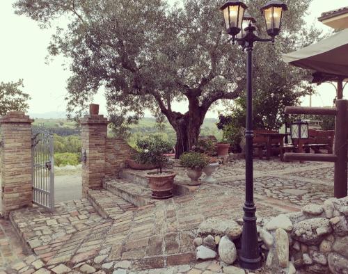 a street light on a stone patio with a tree at Casale del Sole in Cepagatti