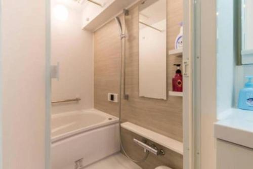 a bathroom with a tub and a toilet and a sink at HAMAMATSUCHO Mansion #2DK# Minato-ku in Tokyo