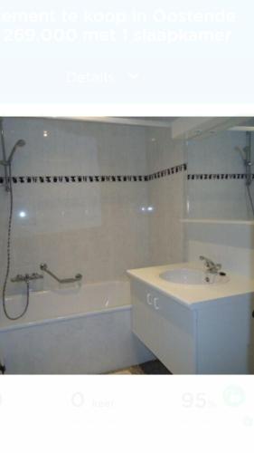 a bathroom with a sink and a bath tub and a bath tub at Appartement "Zeezicht 002" in Ostend