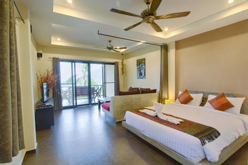 um quarto com uma cama grande e uma ventoinha de tecto em Koh Tao Heights Exclusive Apartments em Ko Tao