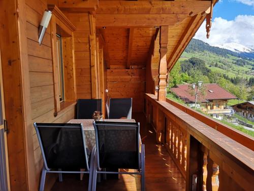 a balcony of a log cabin with chairs and a table at Haus Kristall in Alpbach