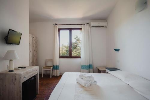 ポザーダにあるResort Fior di Sardegnaの白いベッドルーム(ベッド1台、窓付)