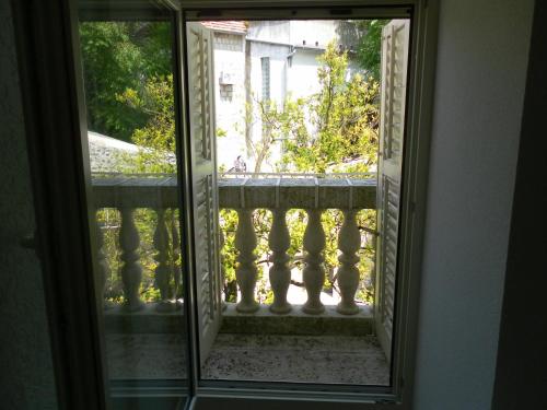 a glass door with a view of a balcony at Apartments David in Perast