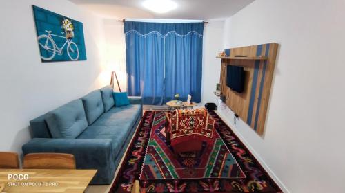 a living room with a blue couch and a tv at Snjezna pahuljica in Bjelašnica