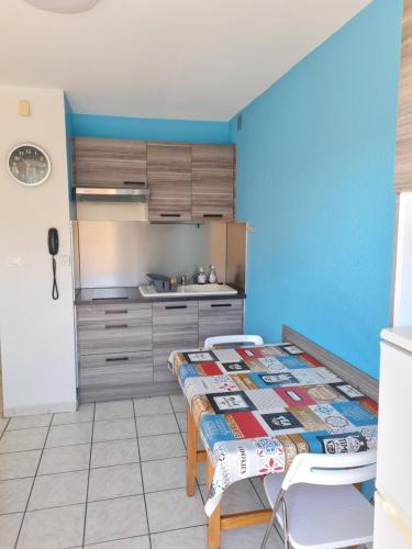 a kitchen with a table in a room at Studio Balaruc les Bains, vue sur l'étang de Thau classement 2 étoiles in Balaruc-les-Bains