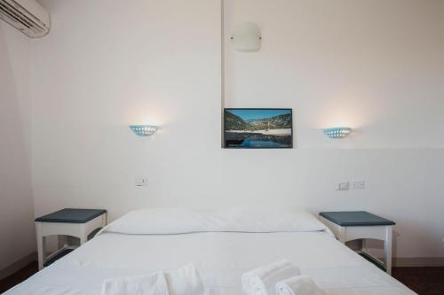 a bedroom with two beds and two tables at Resort Fior di Sardegna in Posada