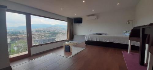 a bedroom with a bed and a large window at Beautiful View Of Sarajevo Center in Sarajevo