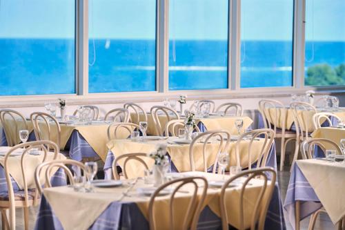 a banquet hall with tables and chairs and windows at Hotel Gran Vista Plava Laguna in Poreč