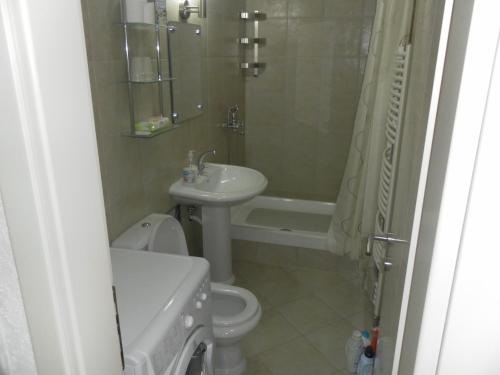 a bathroom with a sink and a toilet and a bath tub at Apartments David in Perast