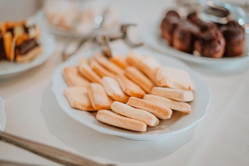 a plate of hot dogs and other foods on a table at Resort Fior di Sardegna in Posada