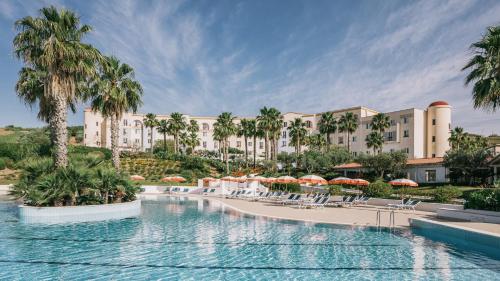 馬里內拉迪塞利的住宿－Mangia's Selinunte Resort，一个带游泳池、椅子和遮阳伞的度假村