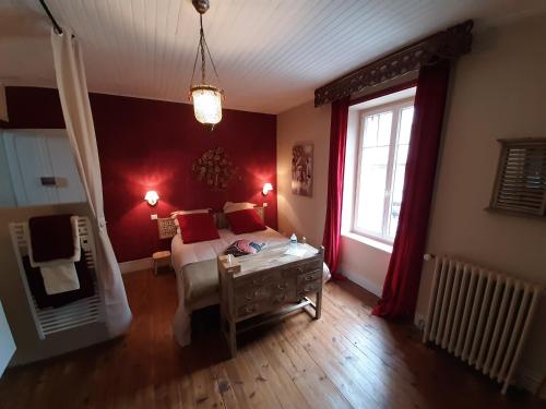een slaapkamer met een bed met rode muren en een raam bij CHEZ TANTE SOLY in Le Chambon-sur-Lignon