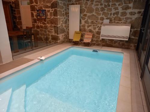 a large swimming pool in a room with a table and chairs at CHEZ TANTE SOLY in Le Chambon-sur-Lignon