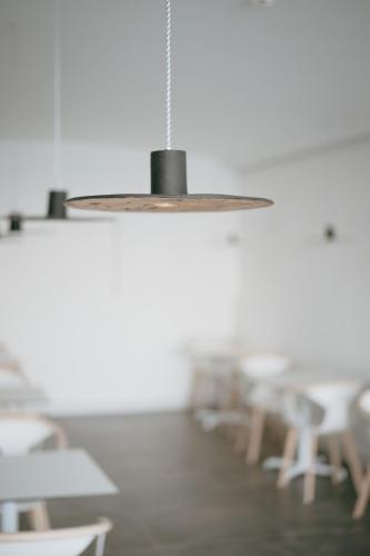 a pendant light in a room with tables and chairs at Mon Signor in Kamari