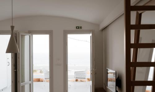 a room with a sliding glass door with a view of the ocean at Mon Signor in Kamari