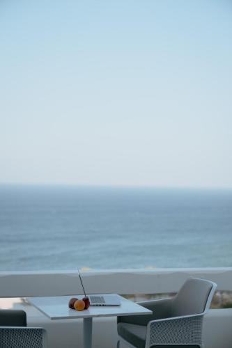 a table with a laptop on it next to the beach at Mon Signor in Kamari